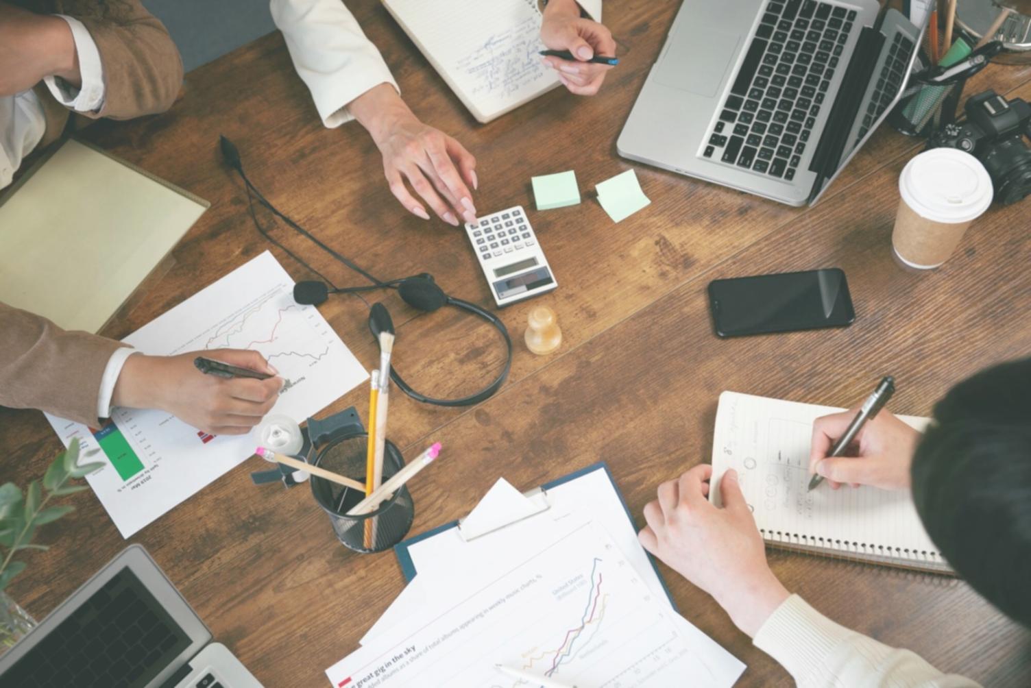 Profesional trabajando con análisis financieros en múltiples dispositivos