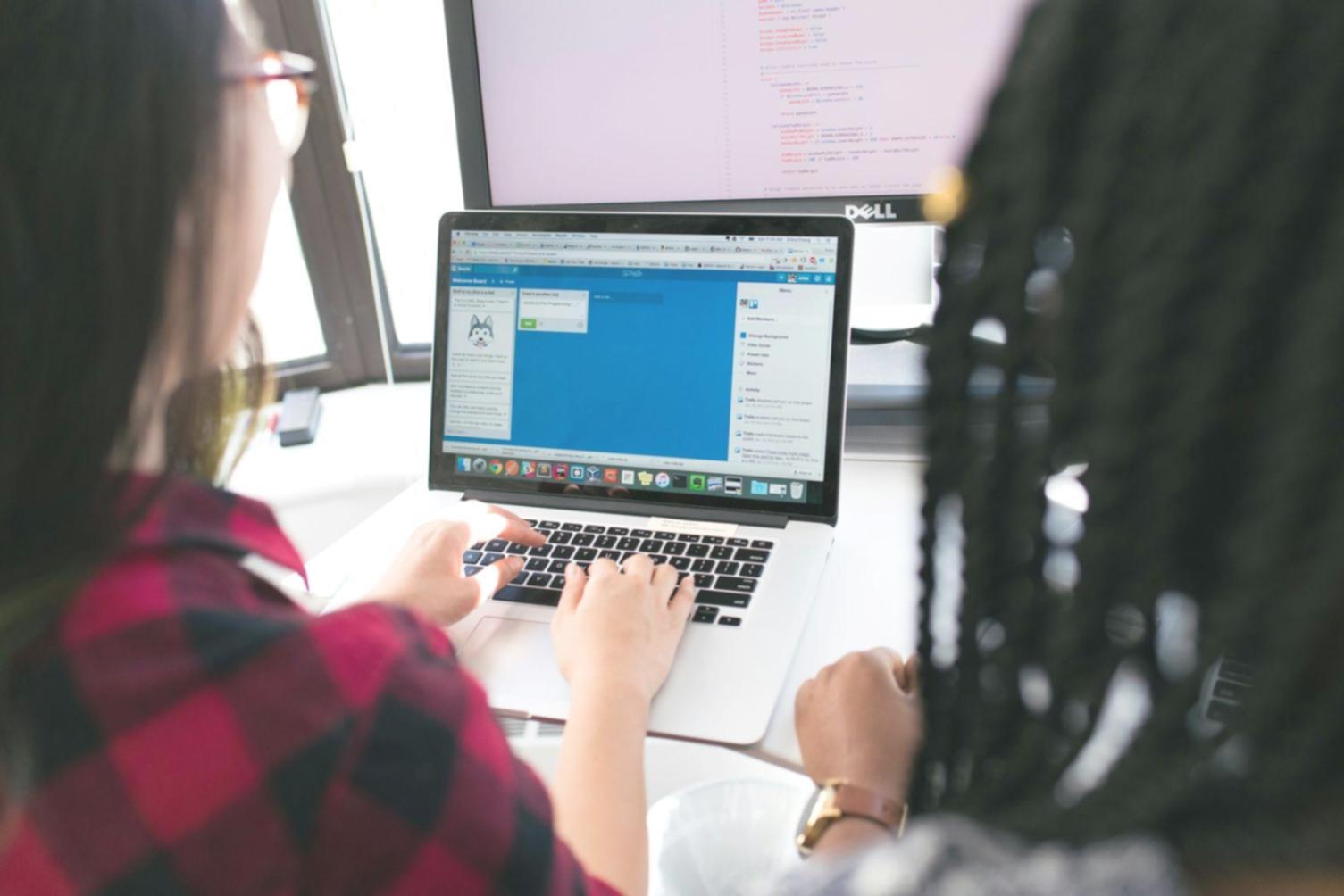 Espacio de trabajo optimizado para formación financiera digital con múltiples pantallas y recursos organizados
